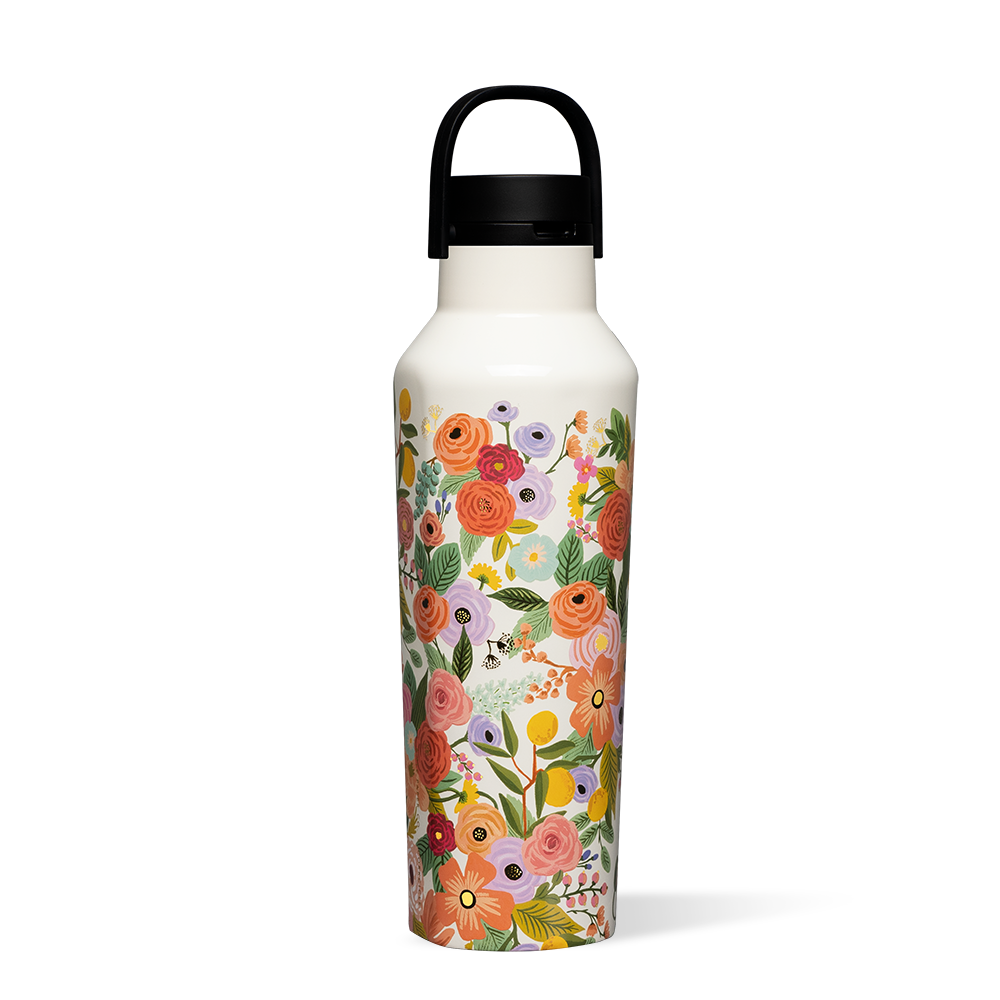 A geometric, brightly colored Corkcicle Canteen standing next to a glass of ice water.